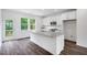 Bright kitchen with white cabinets, stainless appliances, granite countertops and dark laminate flooring at 427 Rowe Way, Knightdale, NC 27545