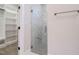 Bathroom featuring a glass-door shower with marble tile, shelving, and an organized walk-in closet at 428 Hampshire Ct, Four Oaks, NC 27524
