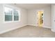 A bedroom with a bright window and neutral paint and carpet at 428 Hampshire Ct, Four Oaks, NC 27524