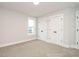 Bright bedroom with plush carpeting, window, and white closets at 428 Hampshire Ct, Four Oaks, NC 27524