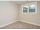 Bedroom with a large window overlooking trees, neutral paint and carpeted flooring at 428 Hampshire Ct, Four Oaks, NC 27524