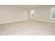 Bright and spacious bedroom with plush carpeting and two windows at 428 Hampshire Ct, Four Oaks, NC 27524