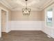 Elegant dining room featuring a coffered ceiling, wainscoting, and a modern chandelier at 428 Hampshire Ct, Four Oaks, NC 27524
