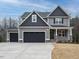 Charming two-story home with gray siding, dark roof, and a spacious three-car garage at 428 Hampshire Ct, Four Oaks, NC 27524