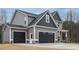 Stunning exterior elevation with stone accents and a three-car garage at 428 Hampshire Ct, Four Oaks, NC 27524