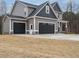 Side view of a beautiful two-story house with a three-car garage and well-maintained lawn at 428 Hampshire Ct, Four Oaks, NC 27524