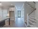 Hallway with staircase, shaker doors, hardwood floors, and kitchen in the background at 428 Hampshire Ct, Four Oaks, NC 27524