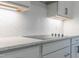 Bright kitchen featuring white cabinets, herringbone backsplash, quartz counters, and stainless steel appliances at 428 Hampshire Ct, Four Oaks, NC 27524