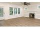 Open living room with large windows, hardwood floors, and fireplace at 428 Hampshire Ct, Four Oaks, NC 27524