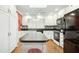 Bright kitchen featuring white cabinetry, black countertops, stainless steel appliances, and a large island at 5405 Fireside Dr, Raleigh, NC 27609