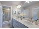 Bathroom showcasing double sinks, white cabinets, modern fixtures, and a glass shower at 615 Contento Ct, Sanford, NC 27330