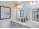 Bathroom with double sinks, white cabinets, granite counters, modern fixtures, and framed mirrors at 615 Contento Ct, Sanford, NC 27330