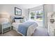 Bright guest bedroom featuring a tufted headboard, cool color palette, and a view of the outdoors at 615 Contento Ct, Sanford, NC 27330