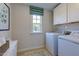 Bright laundry room featuring a front load washer and dryer with cabinets for storage at 615 Contento Ct, Sanford, NC 27330