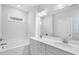 Bright bathroom with double vanity and tub with tile surround at 617 Spellbrook Rd, Zebulon, NC 27597
