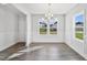 Bright dining room featuring hardwood floors, white trim, a modern chandelier, and large windows at 617 Spellbrook Rd, Zebulon, NC 27597