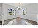 Bright dining room featuring hardwood floors, white trim, a modern chandelier, and large windows at 617 Spellbrook Rd, Zebulon, NC 27597