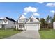 New home featuring a well-manicured lawn, light gray siding, black shutters, and a two car garage at 617 Spellbrook Rd, Zebulon, NC 27597