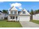 New two-story home featuring a well-manicured lawn, gray siding, black shutters, and a two car garage at 617 Spellbrook Rd, Zebulon, NC 27597