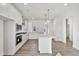 Spacious kitchen featuring white cabinets, granite countertops, stainless steel appliances, and wood flooring at 617 Spellbrook Rd, Zebulon, NC 27597