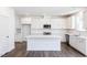 Bright kitchen features white cabinets, stainless appliances, large island, and stylish backsplash at 619 Contento Ct, Sanford, NC 27330