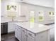 Bright kitchen featuring white cabinets, stainless appliances, and large island looking out at the backyard at 619 Contento Ct, Sanford, NC 27330