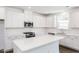 Bright kitchen features white cabinets, stainless appliances, large island, and stylish backsplash at 619 Contento Ct, Sanford, NC 27330