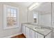 Bathroom featuring double sinks, granite counters, white cabinets, and natural lighting at 6309 Charmco Ct, Wake Forest, NC 27587
