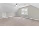 Spacious carpeted room featuring a ceiling fan and a bright window illuminating the neutral walls at 6309 Charmco Ct, Wake Forest, NC 27587