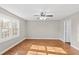 Spacious bedroom features a ceiling fan, hardwood floors, and a large window for ample natural light at 6309 Charmco Ct, Wake Forest, NC 27587