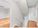 Hallway with hardwood floors and access to a bedroom, stairs, and door, creating a cohesive flow at 6309 Charmco Ct, Wake Forest, NC 27587
