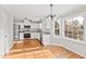 Open kitchen area with stainless steel appliances, white cabinets, granite counters, and hardwood floors at 6309 Charmco Ct, Wake Forest, NC 27587