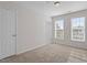 A bright bedroom with two large windows and plush carpet flooring at 650 Ganyard Farm Way # 13, Durham, NC 27703
