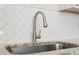 Modern kitchen sink with stainless steel fixtures and herringbone tile backsplash at 650 Ganyard Farm Way # 13, Durham, NC 27703