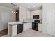 Bright kitchen features white cabinets, granite countertops, and black appliances at 650 Ganyard Farm Way # 13, Durham, NC 27703