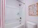 Clean white bathroom with a shower-tub combo and a colorful art piece at 68 Victory View Ter, Smithfield, NC 27577