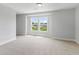 A bright, carpeted room with a double window providing a clear view of the neighborhood at 741 Aristocrat Ln, Knightdale, NC 27545