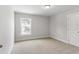 Well-lit bedroom featuring neutral carpet, window view, and white trim at 741 Aristocrat Ln, Knightdale, NC 27545