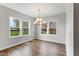 Bright dining room with hardwood floors, a stylish chandelier, and large windows offering outdoor views at 741 Aristocrat Ln, Knightdale, NC 27545