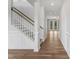 Bright hallway with hardwood flooring, white trim, wainscotting, and open access to other rooms at 741 Aristocrat Ln, Knightdale, NC 27545