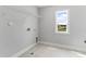 A well-lit laundry room with tile flooring, window, and connections for washer and dryer at 741 Aristocrat Ln, Knightdale, NC 27545