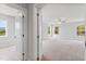 Spacious main bedroom featuring large windows, neutral carpet and paint, and a door to the on-suite bathroom at 741 Aristocrat Ln, Knightdale, NC 27545