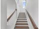 Bright staircase with hardwood steps, white risers, white balusters and wooden handrail at 741 Aristocrat Ln, Knightdale, NC 27545