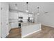 Open kitchen with white cabinets, granite countertops, stainless appliances and hardwood floors at 84 Ripple Way # 313, Clayton, NC 27520