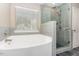 Bright bathroom features a large tub, glass enclosed shower and tile floors at 89 Bison Ln, Lillington, NC 27546