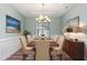 Formal dining room featuring modern chandelier, neutral paint and wood flooring at 89 Bison Ln, Lillington, NC 27546