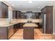Spacious kitchen featuring stainless steel appliances, dark wood cabinetry, and granite countertops at 89 Bison Ln, Lillington, NC 27546