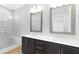Bathroom featuring double sinks, dark wood cabinets, quartz countertops and marble tiled shower with bench at 905 Myers Point Dr, Morrisville, NC 27560