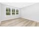 Bright, empty bedroom with hardwood floors and a large window showcasing the green outdoors at 905 Myers Point Dr, Morrisville, NC 27560