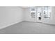 Bright bedroom with gray carpet, white walls and a door to a balcony at 905 Myers Point Dr, Morrisville, NC 27560